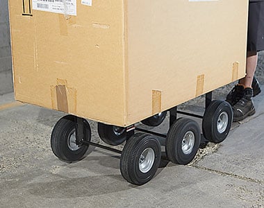 Man pushing a loaded hand truck.